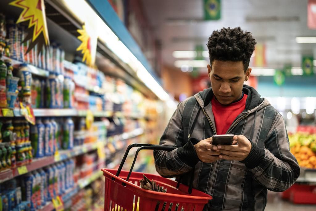 man shopping texting grocery store