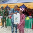 Mr Olusegun Onilude, the Chairman, Badagry Local Government, presenting free food items to Mr Matthew Avoseh, a retired head teacher, during the distribution of free food items to people in Badagry [NAN]