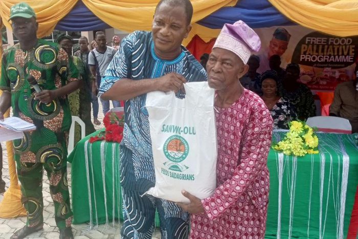 Mr Olusegun Onilude, the Chairman, Badagry Local Government, presenting free food items to Mr Matthew Avoseh, a retired head teacher, during the distribution of free food items to people in Badagry [NAN]