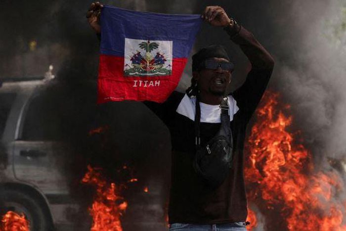 A demonstrator holds up a Haitian flag during protests demanding the resignation of Prime Minister Ariel Henry in Port-au-Prince, Haiti, March 1, 2024 [AP}