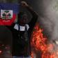 A demonstrator holds up a Haitian flag during protests demanding the resignation of Prime Minister Ariel Henry in Port-au-Prince, Haiti, March 1, 2024 [AP}