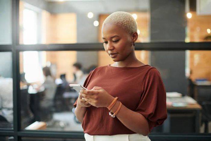 A lady pressing her phone [iStock]
