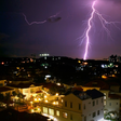 Lightning illuminates the horizon behind a Malaysian cityscape.