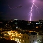 Lightning illuminates the horizon behind a Malaysian cityscape.