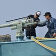In this file photo taken on April 25, 2014 crew members of a whaling ship check a whaling gun or harpoon before departure at Ayukawa port in Ishinomaki City