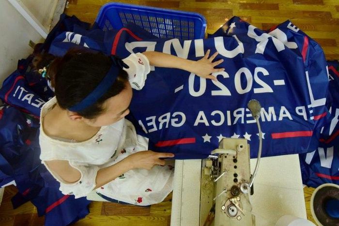 A worker at a factory in China sews a banner for US President Donald Trump's re-election campaign that reads "Trump 2020: Keep America Great"