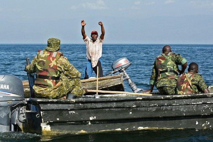 A fisherman from the Democratic Republic of Congo raises his hands to surrender to Uganda forces patrolling Lake Edward, which is shared by the two countries