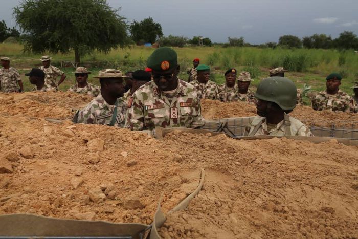 Chief of Army Staff, Lt.-Gen. Tukur Buratai (L), giving instructions to one of the soldiers in trench in frontline in Borno North