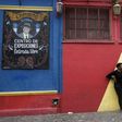 A tourist poses for pictures during a visit to the traditional street museum Caminito in La Boca neighbourhood in Buenos Aires