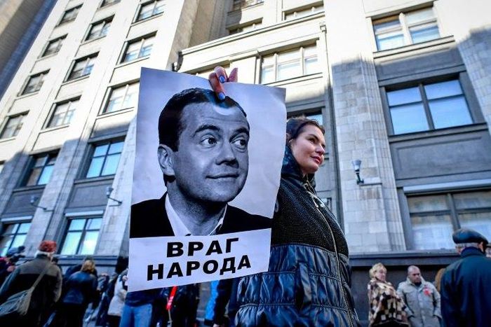 Several dozen people staged a protest outside the State Duma on Wednesday, including one with a picture of Russian Prime Minister Dmitry Medvedev with an inscription reading "An enemy of the people"