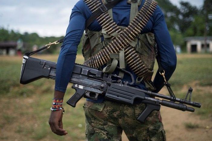 A National Liberation Army (ELN) guerrilla carries a machine gun in a camp on the banks of the San Juan River in the Choco department, in northwestern Colombia