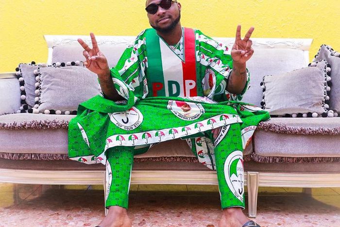 Davido wearing a PDP agbada, a violation of NYSC's bye-laws concerning partisan politics