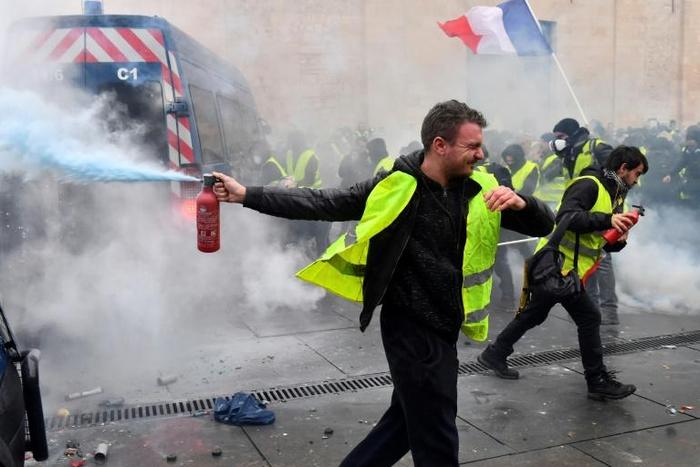 Yellow Vests protesters clash with riot police forces during a demonstration against rising oil prices and living costs in Bordeaux, southwestern France, on December 1, 2018