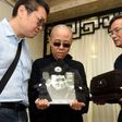 Late Nobel laureate Liu Xiaobo's wife Liu Xia (C) and his brother, Liu Xiaoguang (L), holding a portrait of Liu Xiaobo and receiving the ashes (R) in an urn at a funeral parlour in the Chinese city of Shenyang, Liaoning province