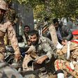 Iranian soldiers and a Shiite Muslim cleric take cover during a gun attack on a military parade in the southwestern city of Ahvaz that has been claimed by the Sunni extremists of the Islamic State group