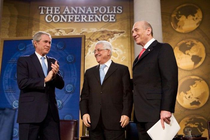 US President George W. Bush applauds then-Israeli prime minister Ehud Olmert (R) and Palestinian President Mahmud Abbas (C) at a peace conference on November 27, 2007
