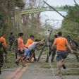 Rescue workers clear a road of debris and toppled electric posts caused by super Typhoon Mangkhut as they try to reach Baggao town