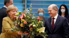 Merkel receives a bouquet from acting German Finance Minister Olaf Scholz on November 24, 2021.