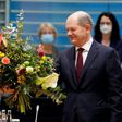Merkel receives a bouquet from acting German Finance Minister Olaf Scholz on November 24, 2021.