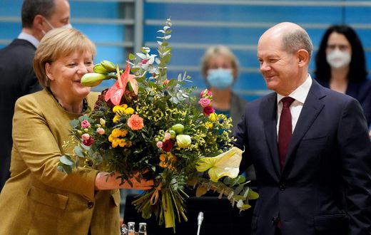 Merkel receives a bouquet from acting German Finance Minister Olaf Scholz on November 24, 2021.