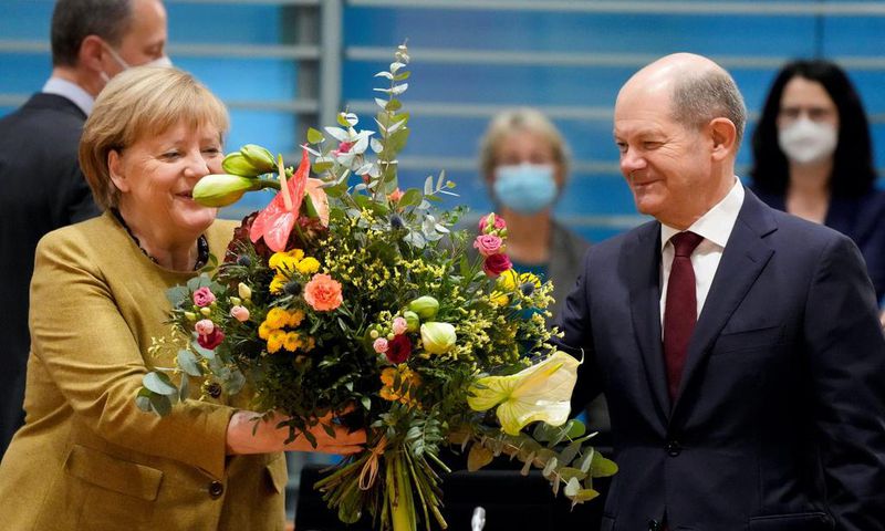 Merkel receives a bouquet from acting German Finance Minister Olaf Scholz on November 24, 2021.