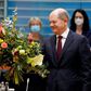 Merkel receives a bouquet from acting German Finance Minister Olaf Scholz on November 24, 2021.