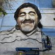 Argentine street artist Alfredo Segatori controls an elevator he uses to paint a mural of late Argentine football legend Diego Maradona in Buenos Aires last December