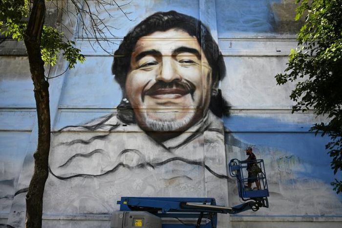 Argentine street artist Alfredo Segatori controls an elevator he uses to paint a mural of late Argentine football legend Diego Maradona in Buenos Aires last December
