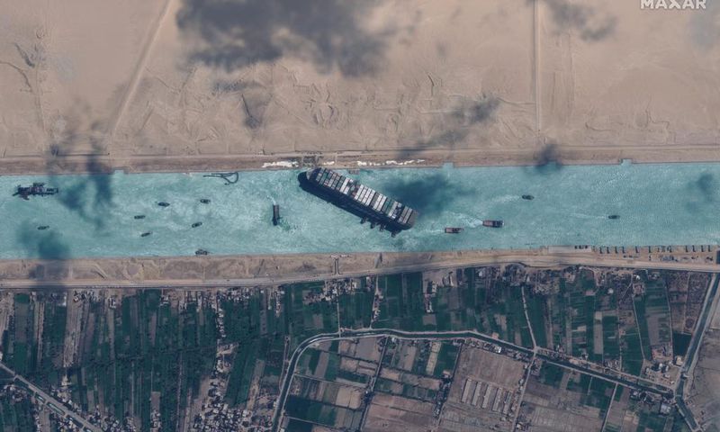 Tugboats work to help free the Even Given ship from the Suez Canal just before noon local time on Monday, March 29, 2021.