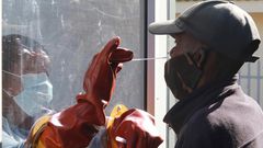 Health worker Vuyiseka Mathambo takes a nasal swab from a patient to test for COVID-19 at a Masiphumelele community centre in Cape Town, South Africa on July 23, 2020.