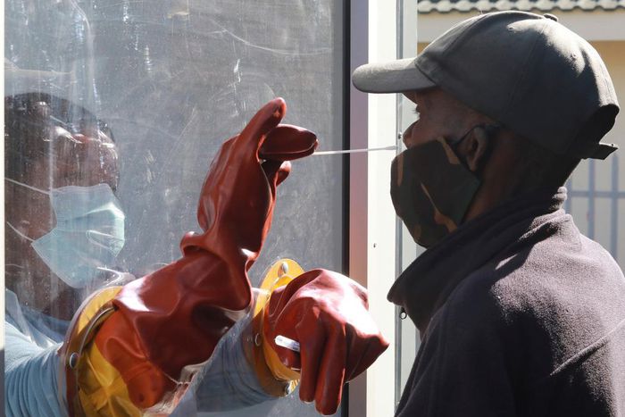 Health worker Vuyiseka Mathambo takes a nasal swab from a patient to test for COVID-19 at a Masiphumelele community centre in Cape Town, South Africa on July 23, 2020.