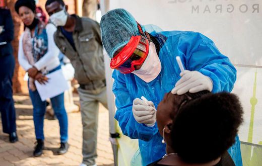 Doctors Without Borders nurse Bhelekazi Mdlalose performs a COVID-19 test on a health worker at the Vlakfontein Clinic in Johannesburg, South Africa on May 13, 2020.