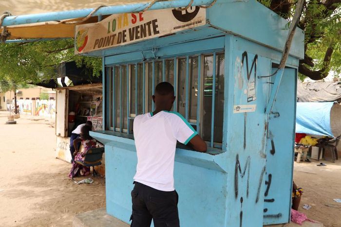 Un parieur devant un point de vente de la LONASE