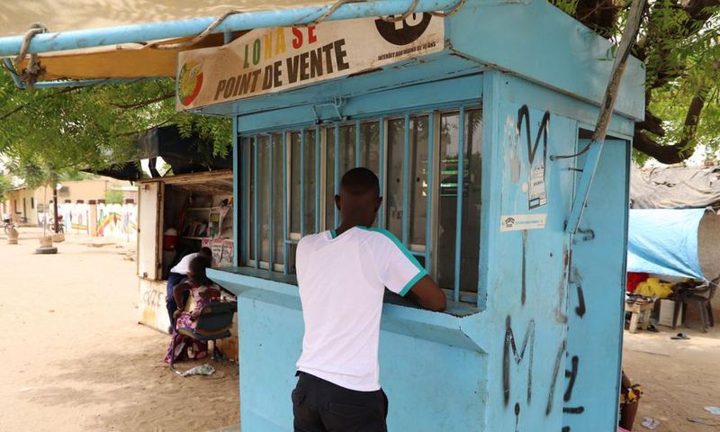 Un parieur devant un point de vente de la LONASE