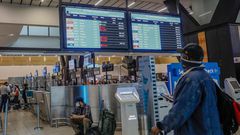 A passenger looks at an electronic flight notice board displaying cancelled flights at Tambo International Airport in Johannesburg on November 27, 2021, after several countries banned flights from South Africa following the discovery of a new coronavir...