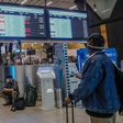 A passenger looks at an electronic flight notice board displaying cancelled flights at Tambo International Airport in Johannesburg on November 27, 2021, after several countries banned flights from South Africa following the discovery of a new coronavir...