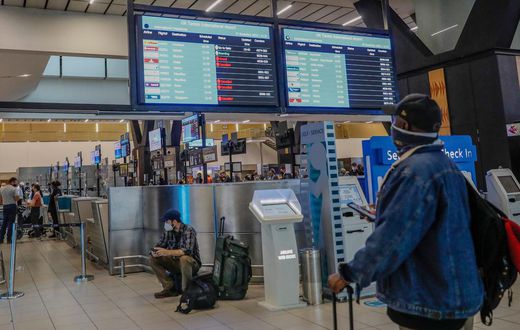 A passenger looks at an electronic flight notice board displaying cancelled flights at Tambo International Airport in Johannesburg on November 27, 2021, after several countries banned flights from South Africa following the discovery of a new coronavir...
