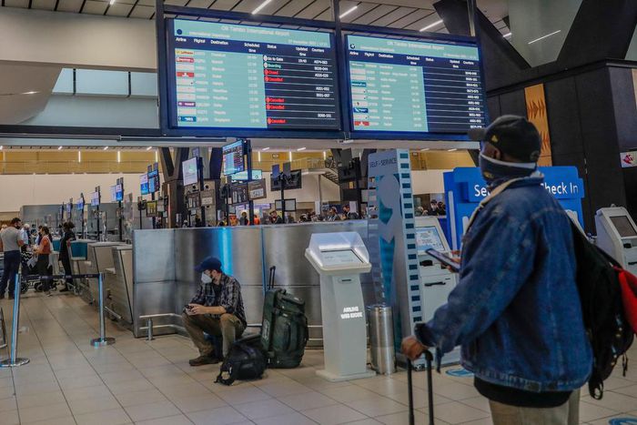 A passenger looks at an electronic flight notice board displaying cancelled flights at Tambo International Airport in Johannesburg on November 27, 2021, after several countries banned flights from South Africa following the discovery of a new coronavir...