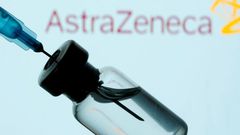 A vial and sryinge are seen in front of a displayed AstraZeneca logo in this illustration taken January 11, 2021.