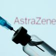 A vial and sryinge are seen in front of a displayed AstraZeneca logo in this illustration taken January 11, 2021.