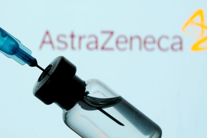 A vial and sryinge are seen in front of a displayed AstraZeneca logo in this illustration taken January 11, 2021.