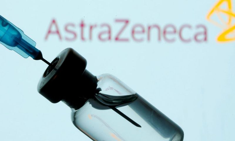 A vial and sryinge are seen in front of a displayed AstraZeneca logo in this illustration taken January 11, 2021.