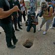 Un policier israélien et des journalistes regardent un trou par où des Palestiniens se sont évadés de la prison de Gilboa (Nord), le 6 septembre 2021 AFP - JALAA MAREY