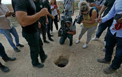 Un policier israélien et des journalistes regardent un trou par où des Palestiniens se sont évadés de la prison de Gilboa (Nord), le 6 septembre 2021 AFP - JALAA MAREY
