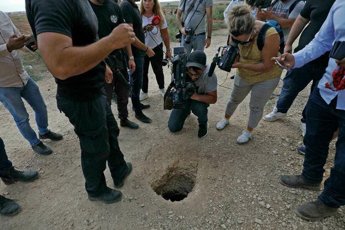 Un policier israélien et des journalistes regardent un trou par où des Palestiniens se sont évadés de la prison de Gilboa (Nord), le 6 septembre 2021 AFP - JALAA MAREY