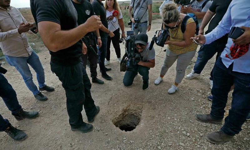 Un policier israélien et des journalistes regardent un trou par où des Palestiniens se sont évadés de la prison de Gilboa (Nord), le 6 septembre 2021 AFP - JALAA MAREY