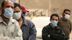 Des hommes égyptiens attendent devant une banque alimentaire, après que des restrictions de mouvement imposées pour lutter contre le coronavirus ont paralysé des moyens de subsistance déjà précaires