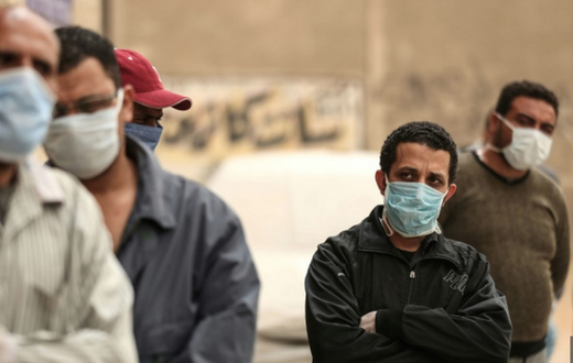 Des hommes égyptiens attendent devant une banque alimentaire, après que des restrictions de mouvement imposées pour lutter contre le coronavirus ont paralysé des moyens de subsistance déjà précaires
