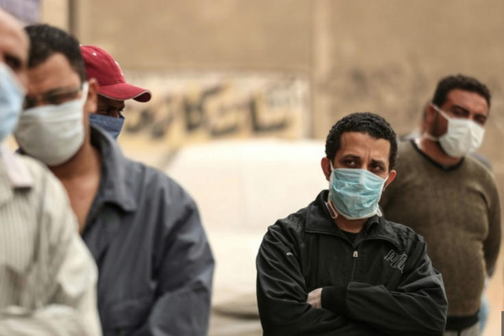 Des hommes égyptiens attendent devant une banque alimentaire, après que des restrictions de mouvement imposées pour lutter contre le coronavirus ont paralysé des moyens de subsistance déjà précaires