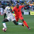 South Africa goalkeeper Itumeleng Khune (R) chases Senegal star Sadio Mane during a 2018 World Cup qualifer.